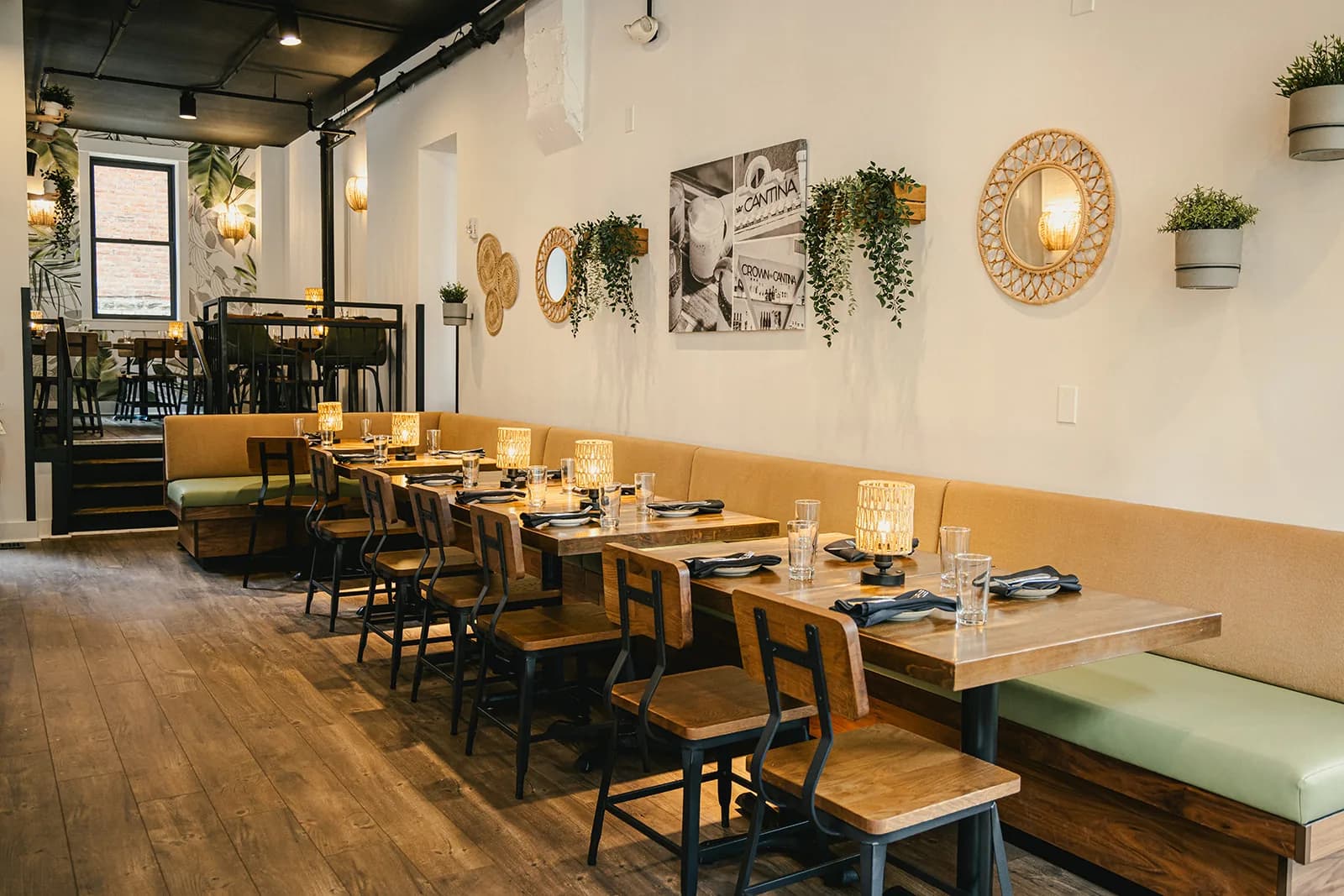 The Crown Cantina dining room — banquette seating, warm wood and hanging greenery