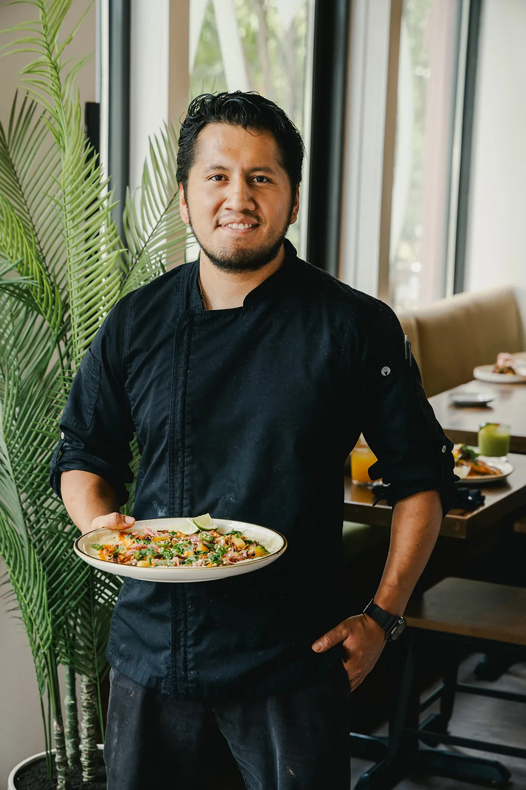 A Crown Cantina chef presenting a finished plate in the dining room